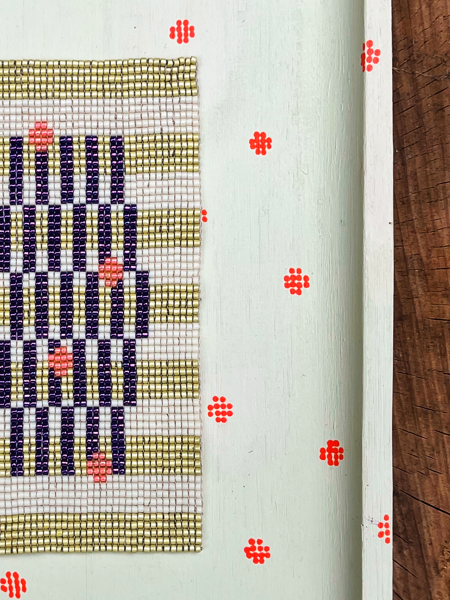 Close-up of indigo and sage striped beadwork with peach bead accents
