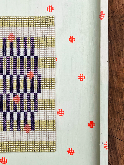 Close-up of indigo and sage striped beadwork with peach bead accents
